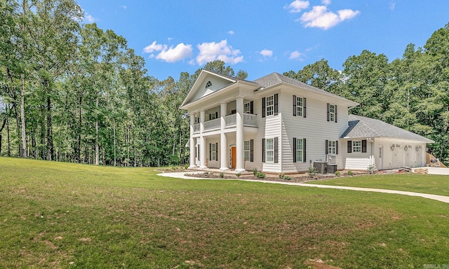 neoclassical home with a balcony, central air condition unit, and a front lawn