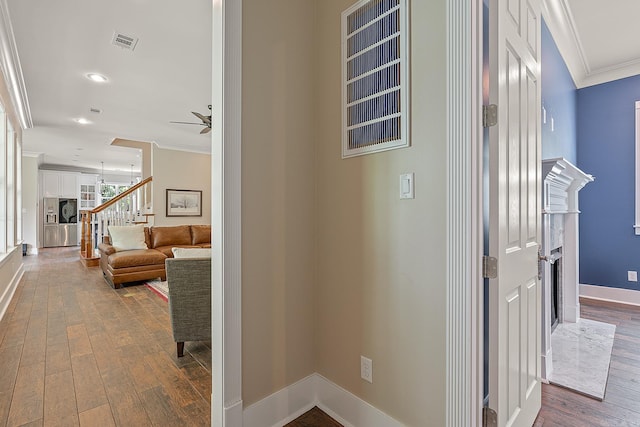 hallway featuring ornamental molding and hardwood / wood-style floors