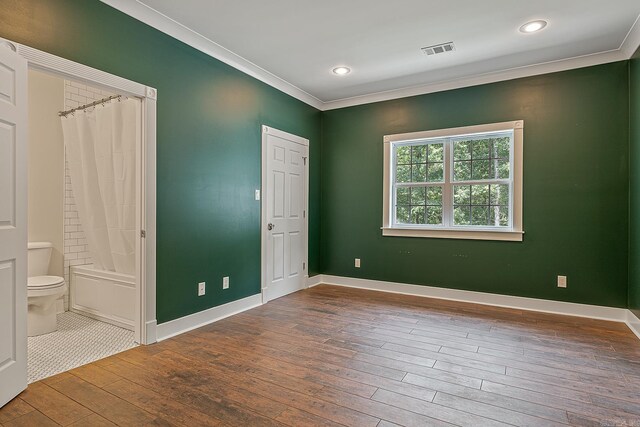 unfurnished bedroom featuring ornamental molding, ensuite bathroom, and tile patterned floors