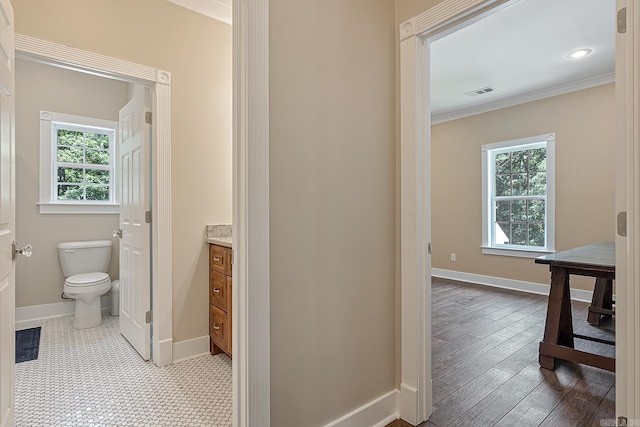 hall with tile patterned floors and crown molding