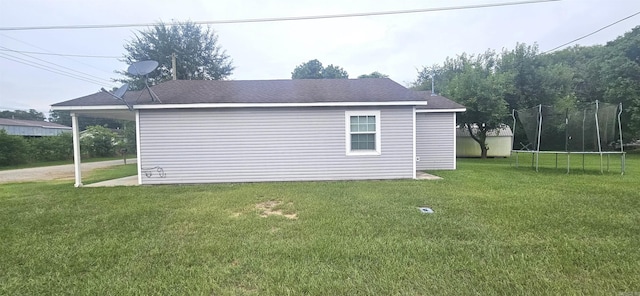 view of home's exterior featuring a trampoline and a yard