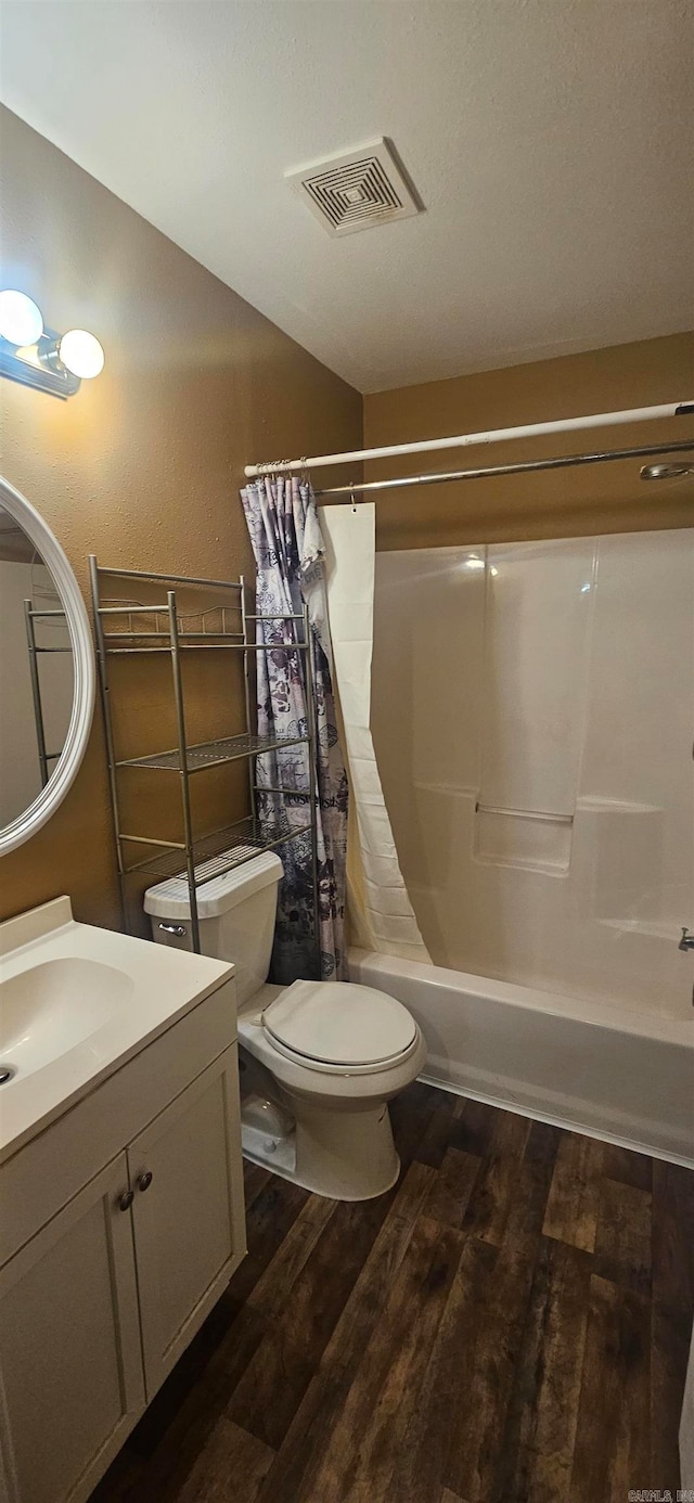 full bathroom featuring vanity, shower / bath combo with shower curtain, hardwood / wood-style flooring, and toilet