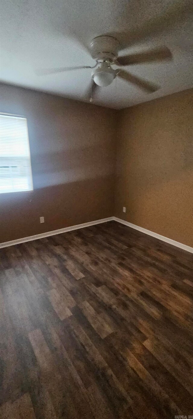 spare room with dark hardwood / wood-style floors, a textured ceiling, and ceiling fan