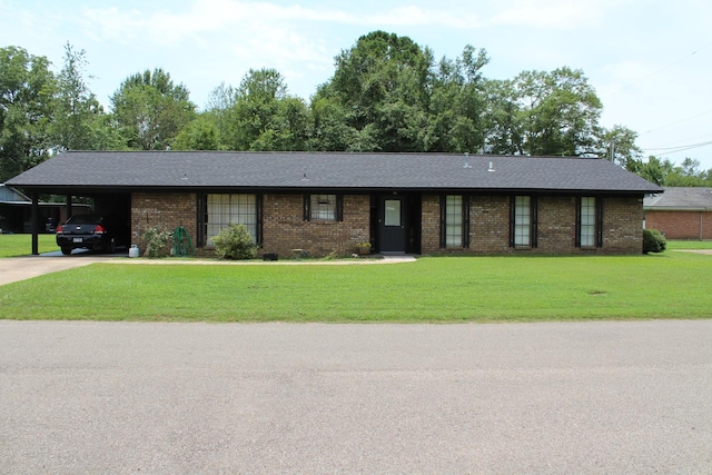 ranch-style home featuring driveway, an attached carport, brick siding, a front lawn, and roof with shingles