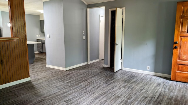 empty room featuring dark hardwood / wood-style floors and ornamental molding