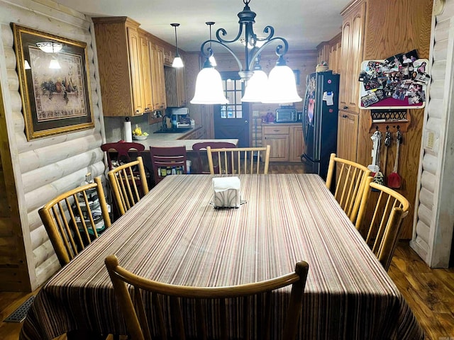 dining area featuring dark wood-type flooring and a chandelier