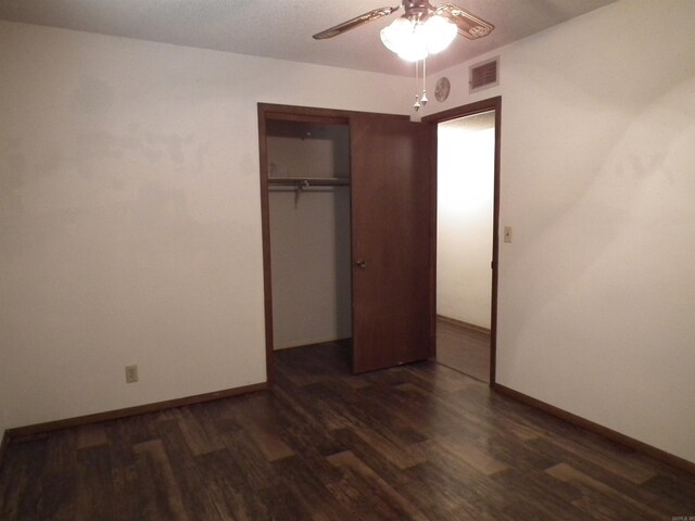 unfurnished bedroom featuring baseboards, visible vents, a ceiling fan, a closet, and wood finished floors