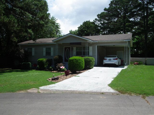 ranch-style house featuring a front yard, an attached carport, and concrete driveway