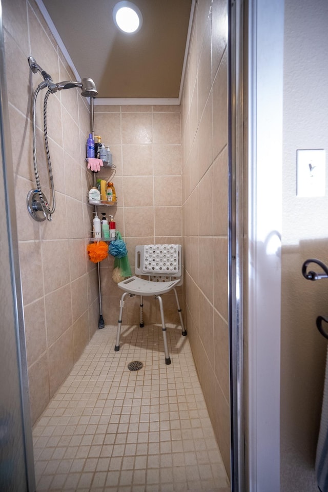 bathroom with tiled shower and crown molding