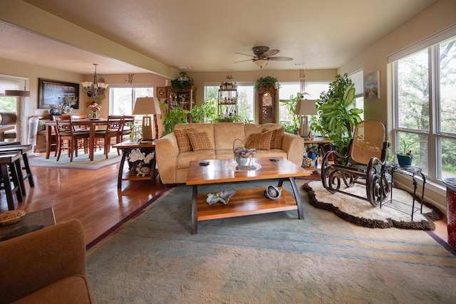 living room featuring hardwood / wood-style floors and ceiling fan with notable chandelier