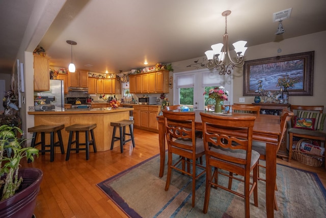 dining room featuring light hardwood / wood-style floors and an inviting chandelier