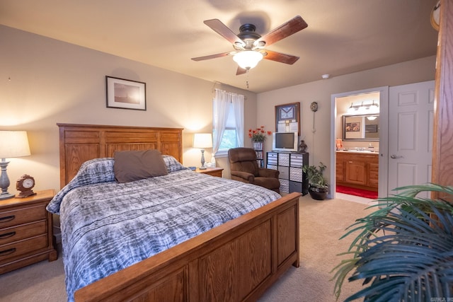 carpeted bedroom with sink, ensuite bath, and ceiling fan