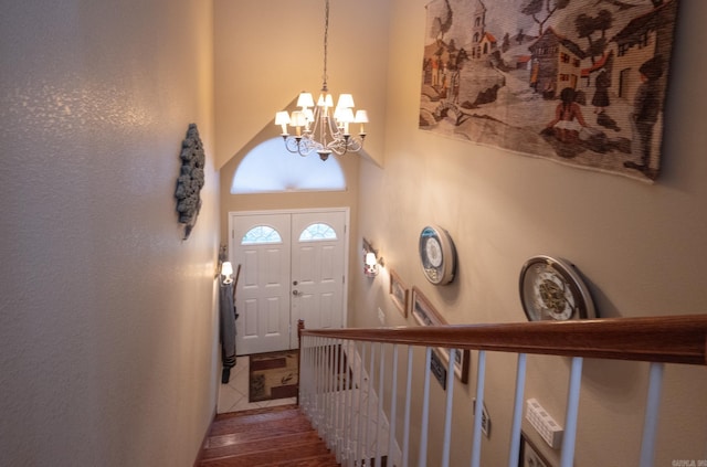 tiled entrance foyer featuring a towering ceiling and an inviting chandelier