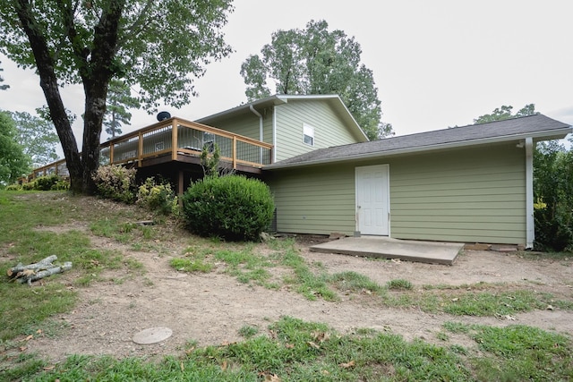 back of property featuring a wooden deck and a patio