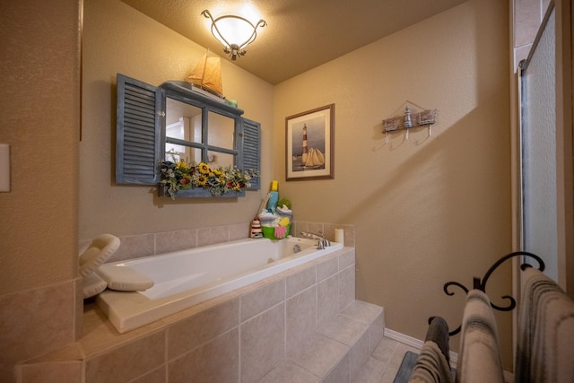 bathroom featuring tiled tub, a textured ceiling, and tile patterned flooring