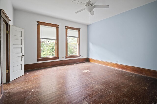 empty room with baseboards, wood-type flooring, and ceiling fan