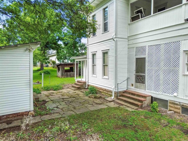 view of side of property with entry steps and a yard