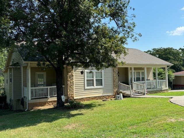 view of front of home featuring covered porch and a front lawn