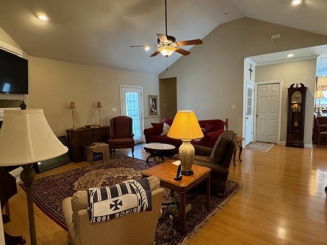 living room featuring lofted ceiling, ceiling fan, and light hardwood / wood-style floors