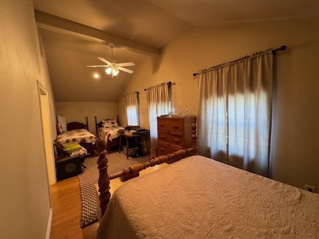 bedroom with ceiling fan, vaulted ceiling, and light hardwood / wood-style flooring