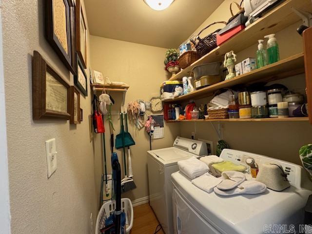 laundry area featuring wood-type flooring and washer and clothes dryer