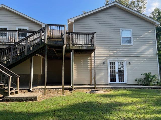 back of house featuring a yard, french doors, and a wooden deck