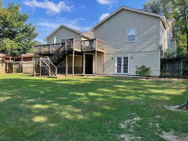 back of house with a wooden deck and a yard