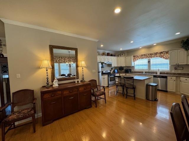 kitchen featuring white cabinets, a breakfast bar, a healthy amount of sunlight, and stainless steel appliances