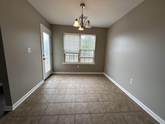 unfurnished dining area featuring a chandelier and tile patterned flooring