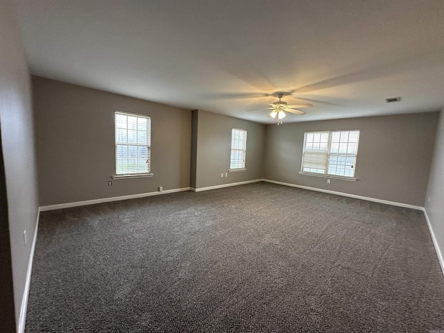 spare room with ceiling fan and dark carpet