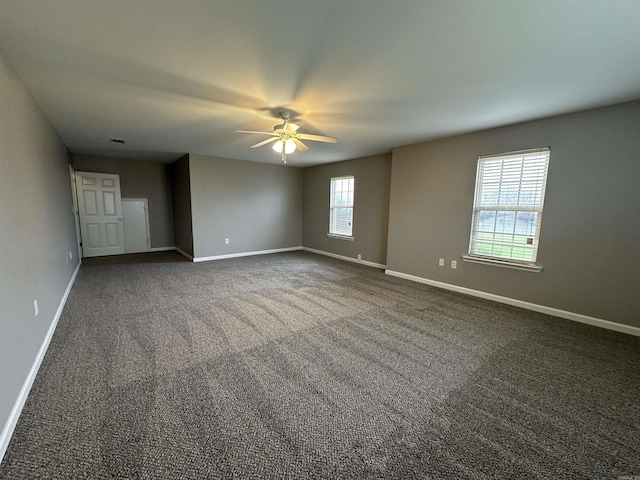 unfurnished room featuring ceiling fan and dark colored carpet