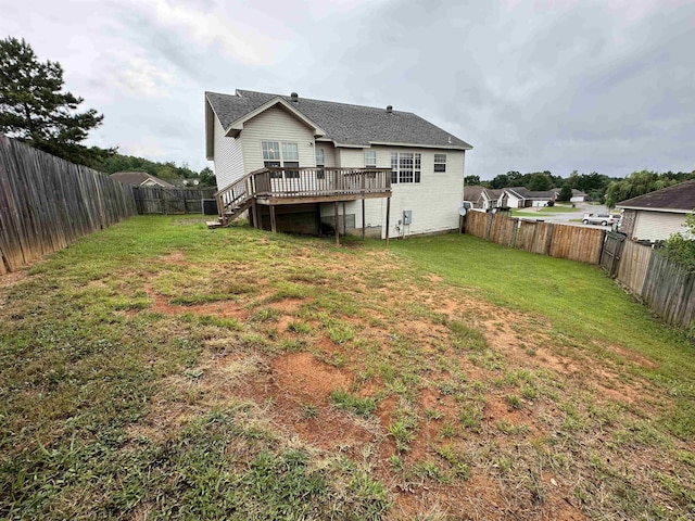 back of house with a lawn and a deck