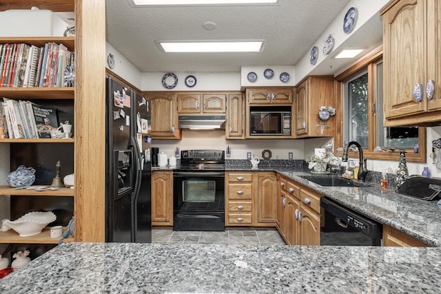 kitchen featuring light tile patterned floors, black appliances, sink, and a textured ceiling