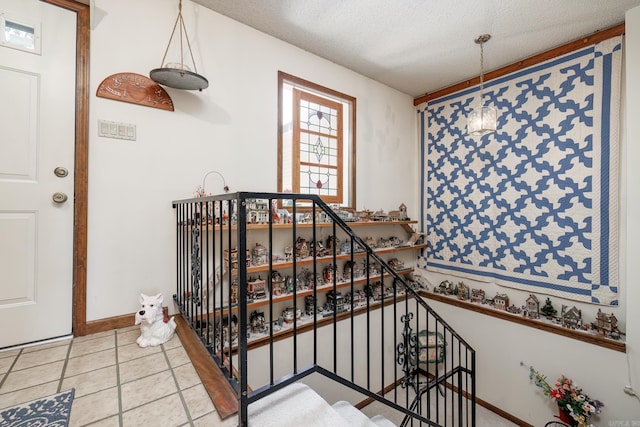 stairs with a textured ceiling and light tile patterned floors