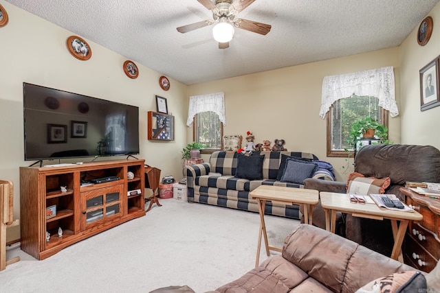 living room featuring a textured ceiling, carpet floors, and ceiling fan