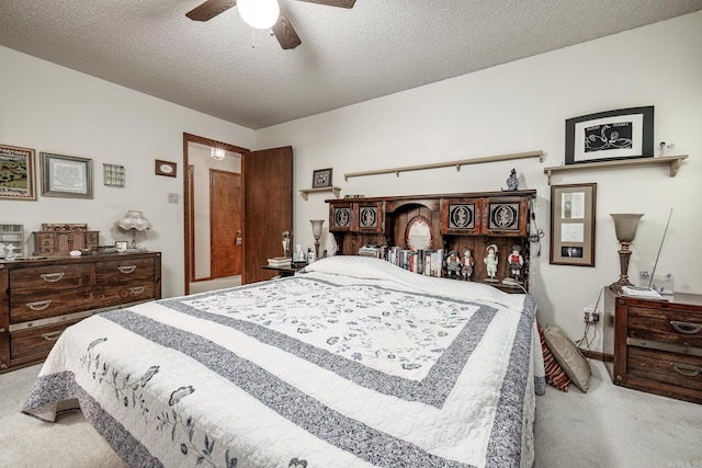 bedroom featuring light carpet, a textured ceiling, and ceiling fan