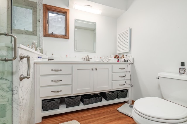 bathroom featuring a shower with door, vanity, hardwood / wood-style flooring, and toilet