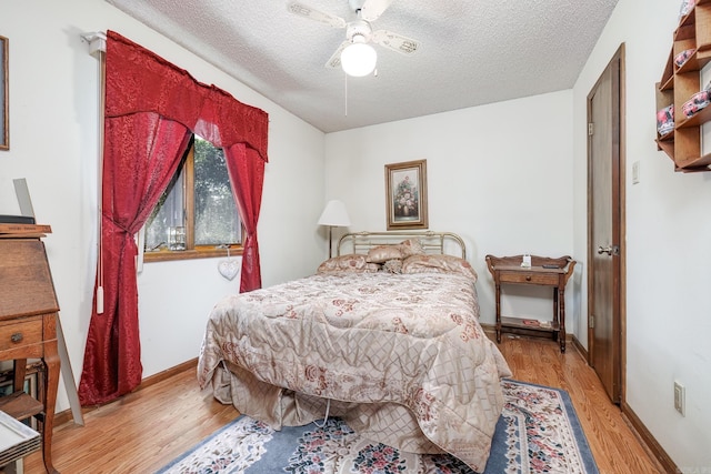 bedroom featuring a textured ceiling, light hardwood / wood-style flooring, and ceiling fan