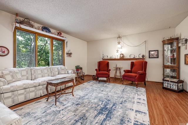 living room featuring light wood-type flooring and a textured ceiling