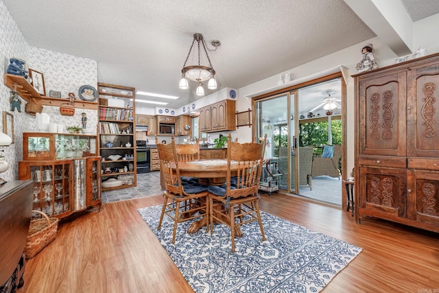 dining room featuring light hardwood / wood-style floors, a textured ceiling, and ceiling fan