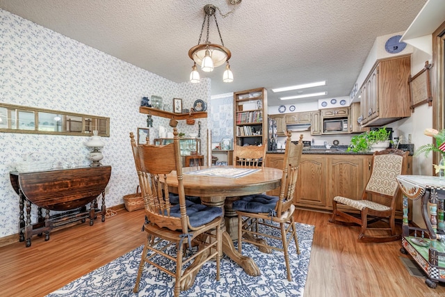 dining room with light hardwood / wood-style floors and a textured ceiling