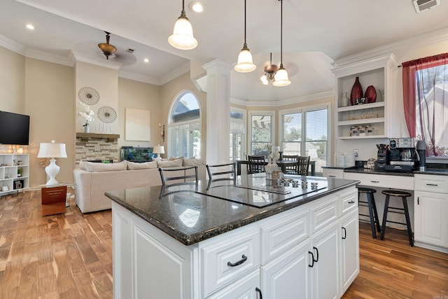 kitchen with white cabinets, a center island, and ornate columns