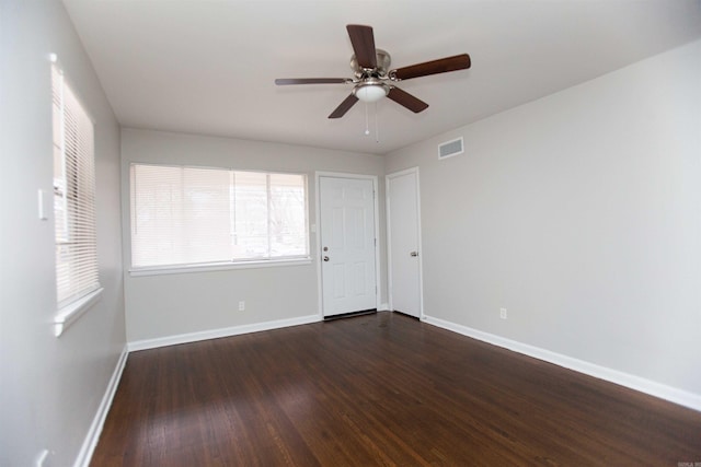 unfurnished room with ceiling fan and dark wood-type flooring