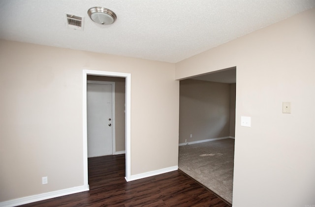 unfurnished room with dark hardwood / wood-style floors and a textured ceiling