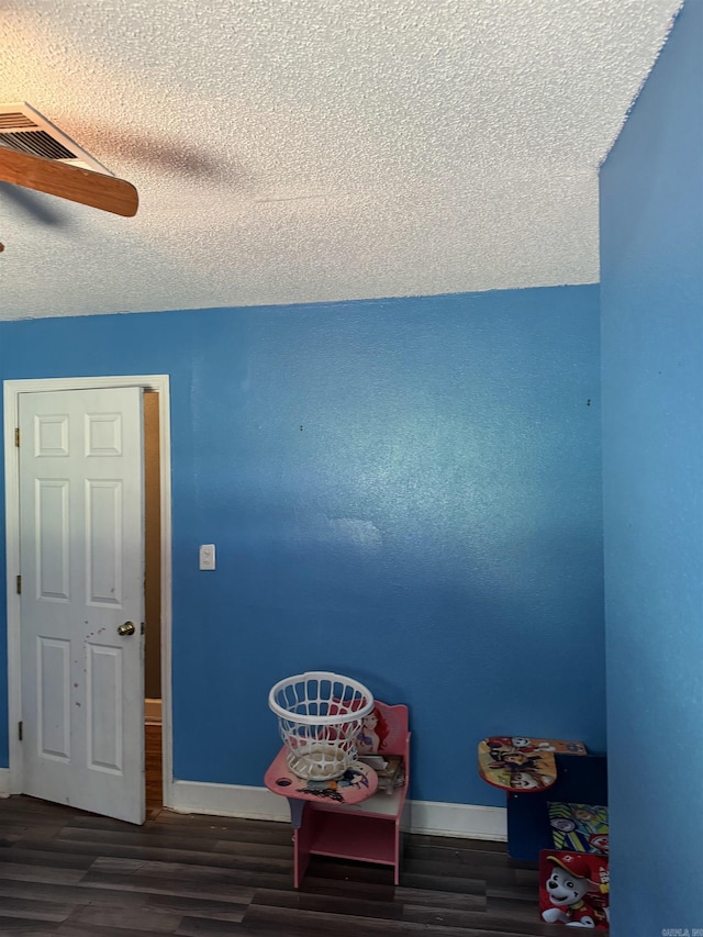 interior space featuring a textured ceiling, ceiling fan, and dark hardwood / wood-style flooring