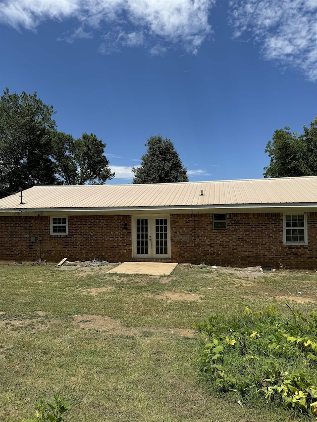 rear view of property with french doors and a lawn