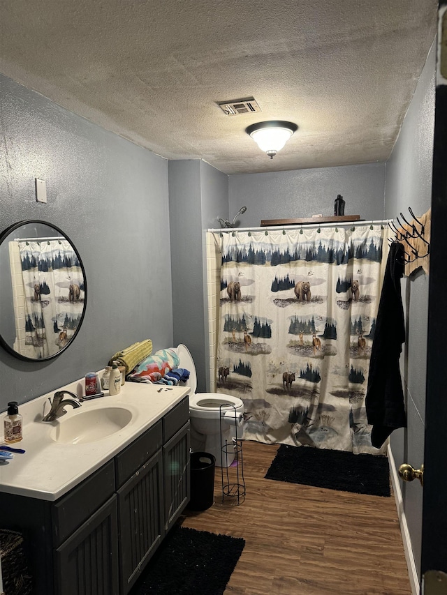 bathroom featuring hardwood / wood-style floors, a textured ceiling, toilet, and vanity