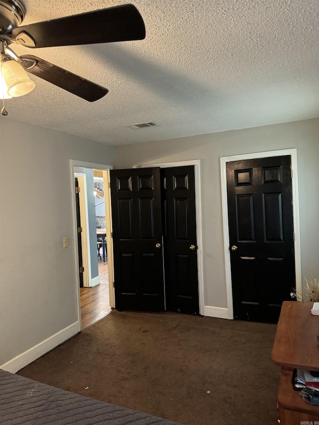 carpeted entrance foyer with ceiling fan and a textured ceiling