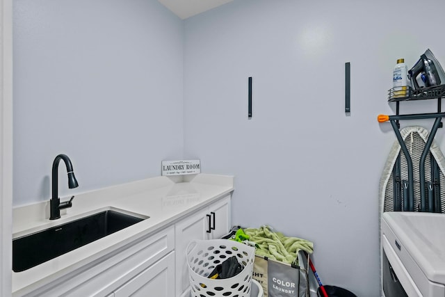 laundry area featuring cabinets, washer and clothes dryer, and sink