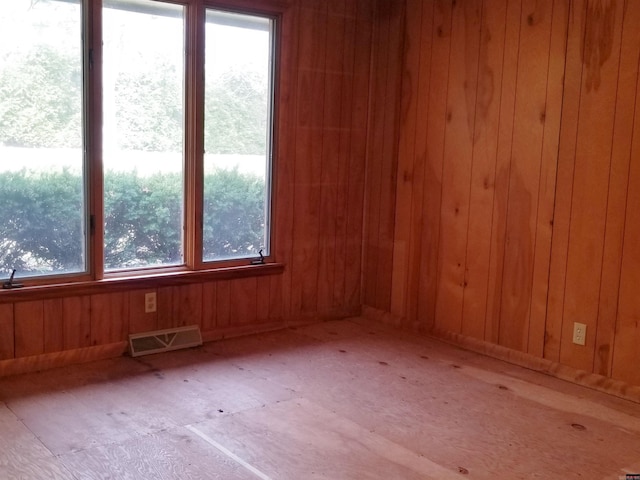 spare room with wood walls